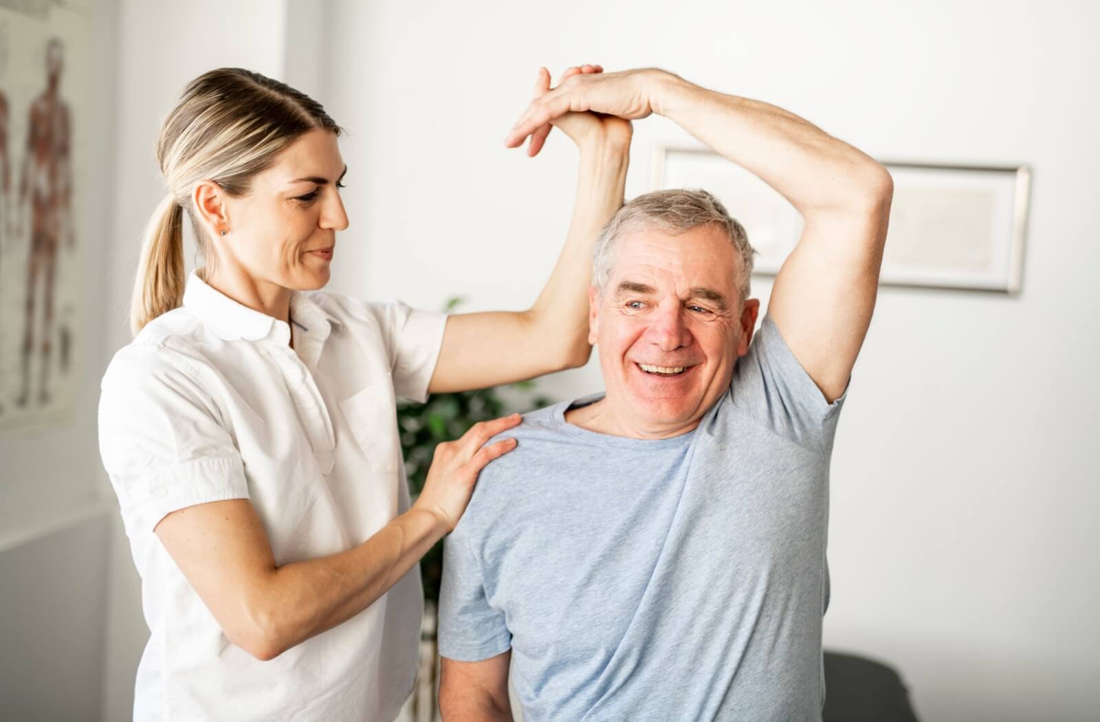 A physiotherapist assists an older adult man with exercises as part of his Powerback Rehabilitation.
