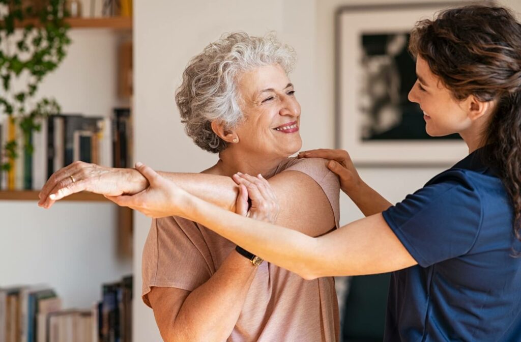 A physical therapist helps an older adult woman perform stretching exercises as part of her Powerback Rehabilitation program.