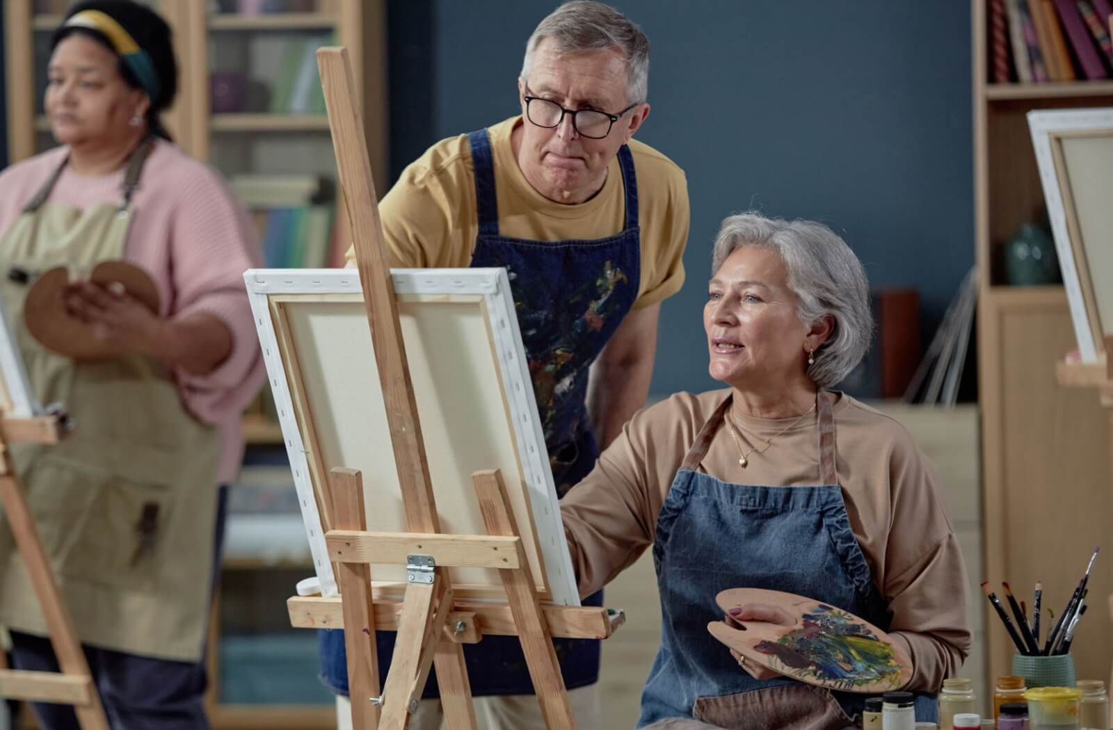 Senior adults painting together in an art class, enjoying a creative and social activity in a welcoming environment.
