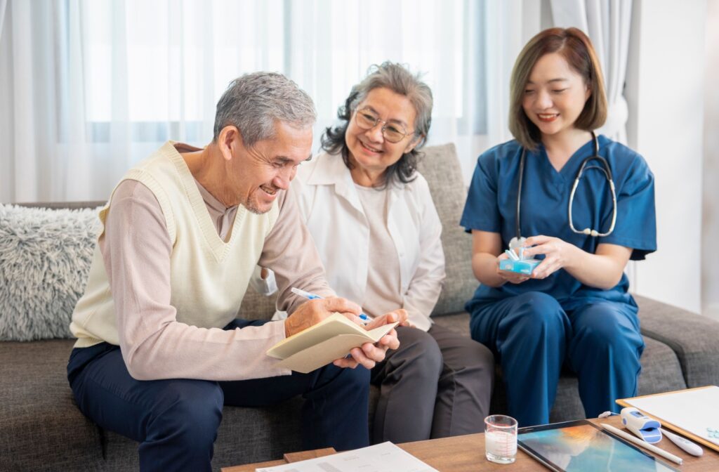 A smiling older adult couple is assisted by a caring nurse in a memory care community.