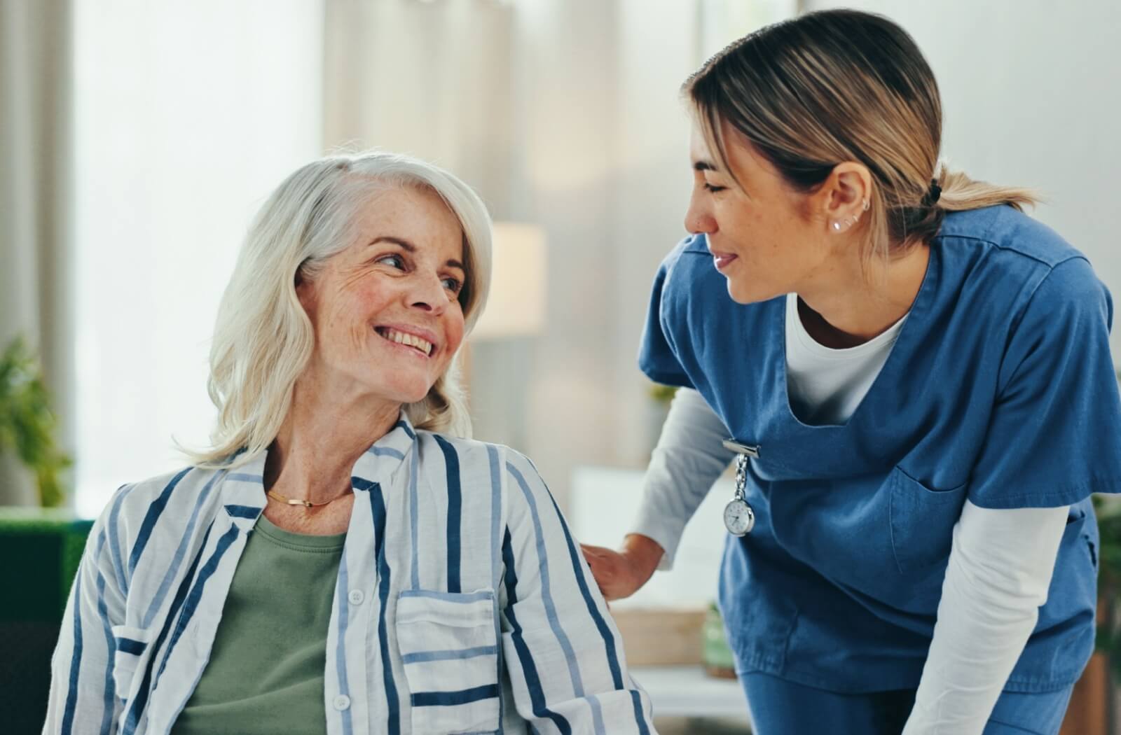 Older adult smiling with a care team member during a personal care community tour