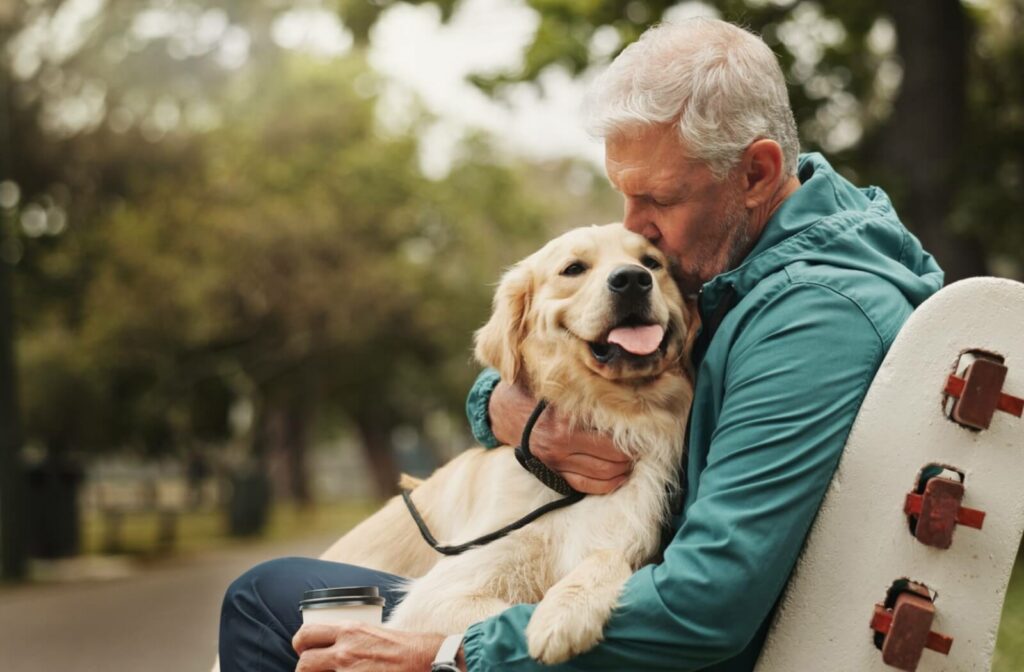 Senior embracing golden retriever outdoors highlighting pet policies in personal care communities